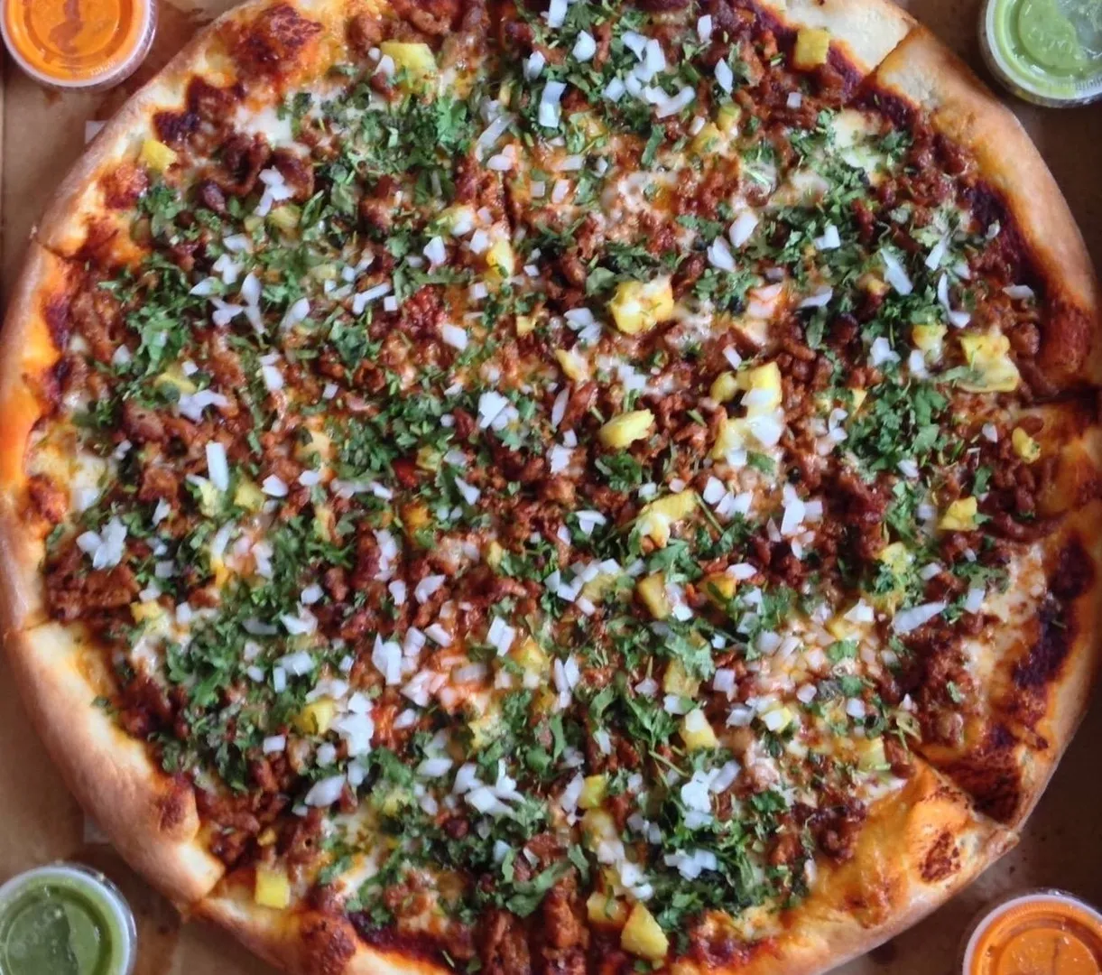 A pizza with toppings on a wooden table.